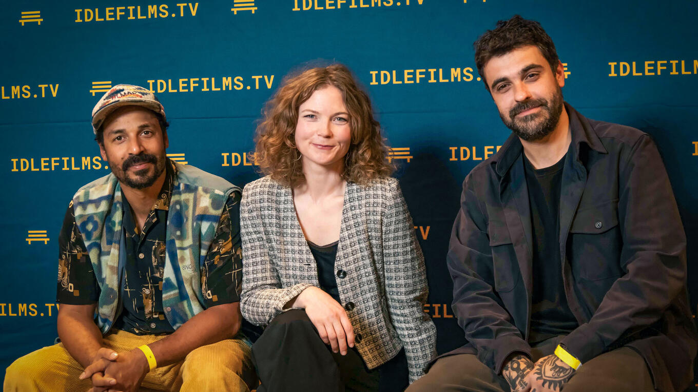 Three people sitting in front of a blue Idle Films backdrop. Left: Tammy Davis wearing a patterned shirt and cap. Center: Verena Gerjets in a checked jacket, smiling. Right: Fernando Silvestrin in a dark shirt, seated with arms crossed.