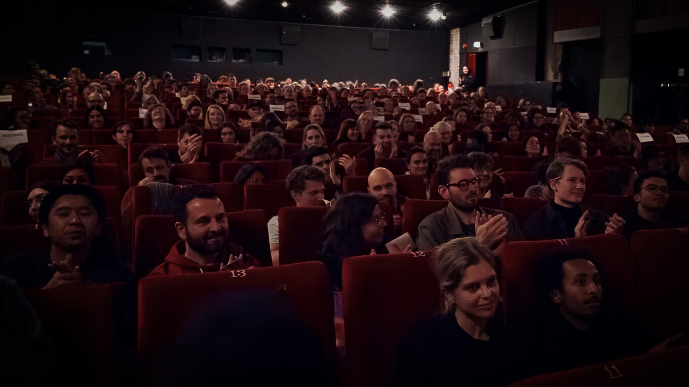 Crowd at Zeise Kino in Hamburg during Idle Films Anthology premiere, showing a packed theater with attentive and applauding audience members.