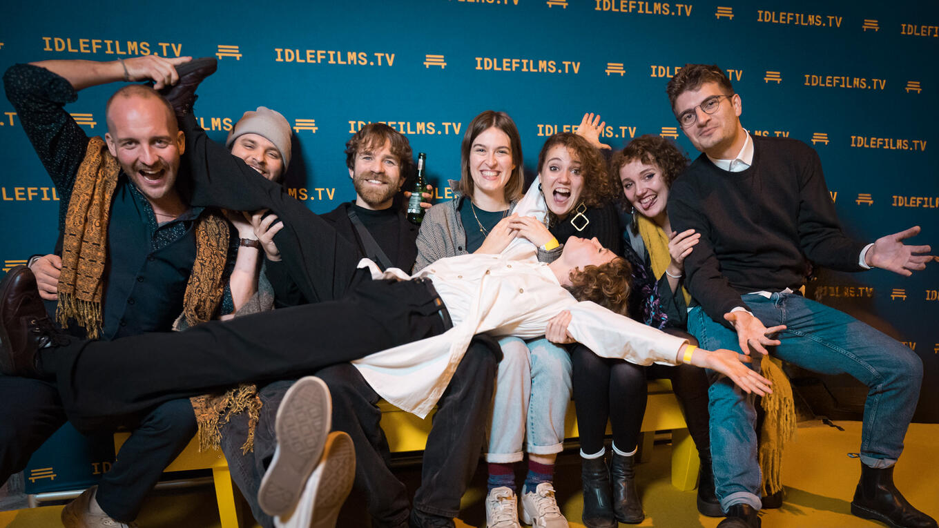 Actress Véréna Garjet at the center of a joyful group photo with fellow actors and friends at the Idle Films premiere.