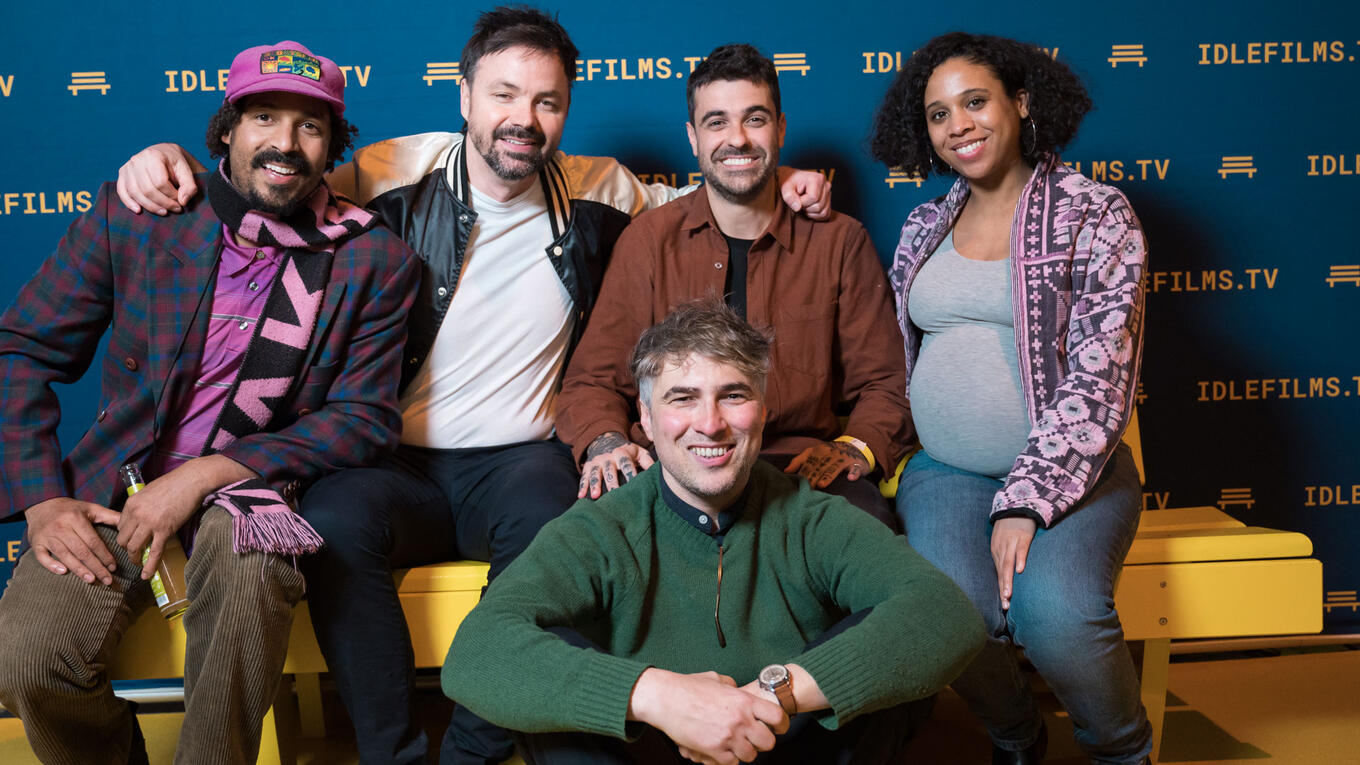 Group portrait of Iliès Terki, Danny Thomas, Timmi Davis, Jennifer Lotsi, Fernando Silvestrin, and Idle Films team members smiling together at the post-screening event in Hamburg.