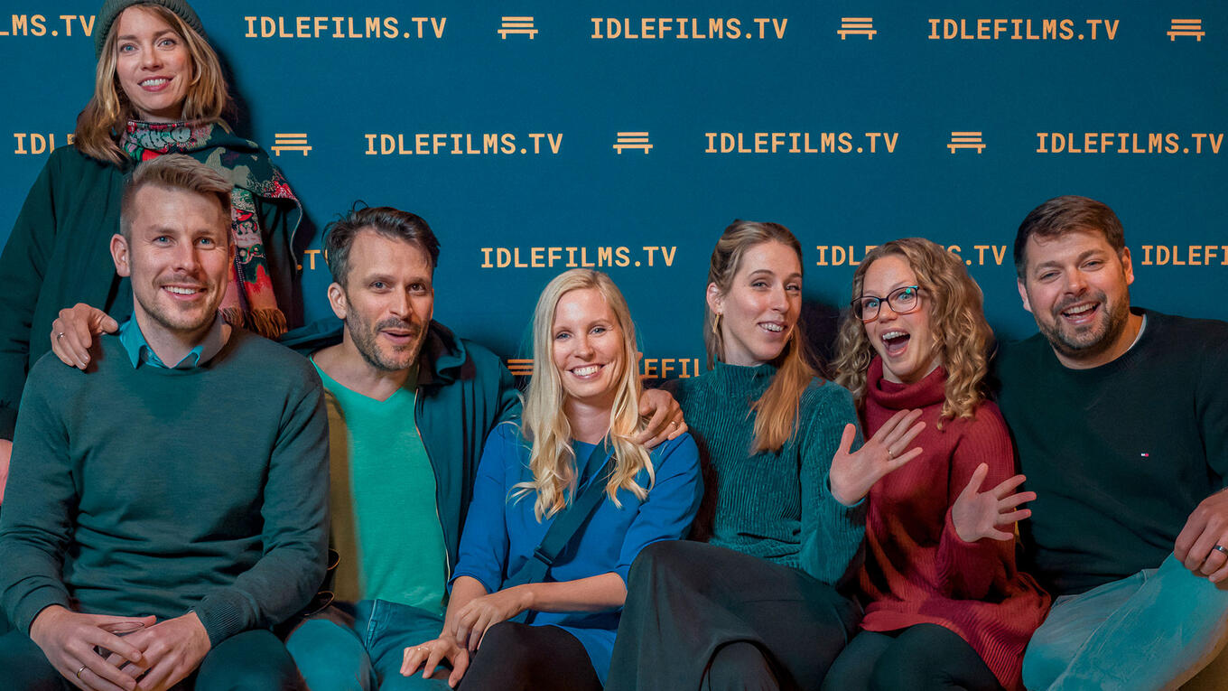 A group of smiling audience members pose together after the Idle Films premiere in Hamburg.