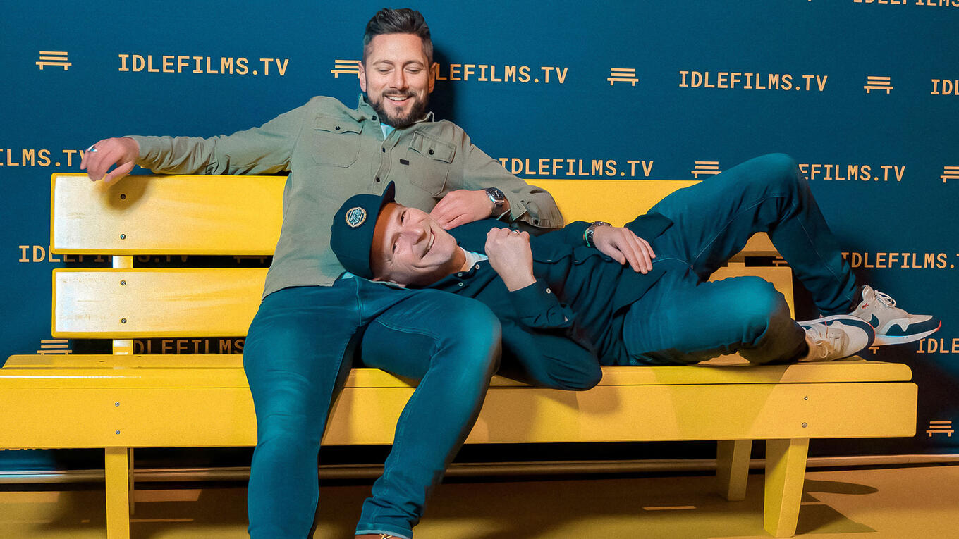 Alen Jelić and Oliver Krupp smile on the Idle Films yellow bench after the Hamburg premiere screening.