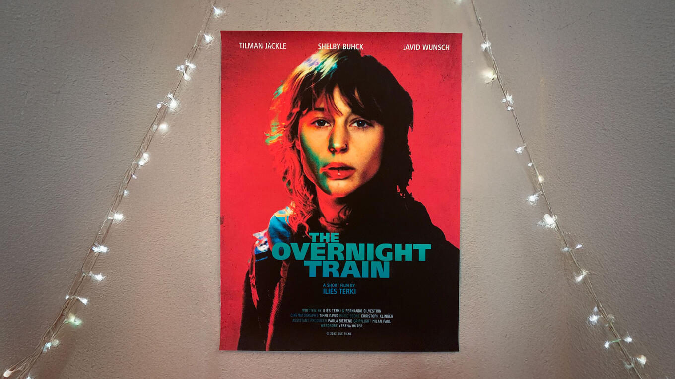 Poster of The Overnight Train with fairy lights around it, shown during a surprise screening at the Berlin premiere.
